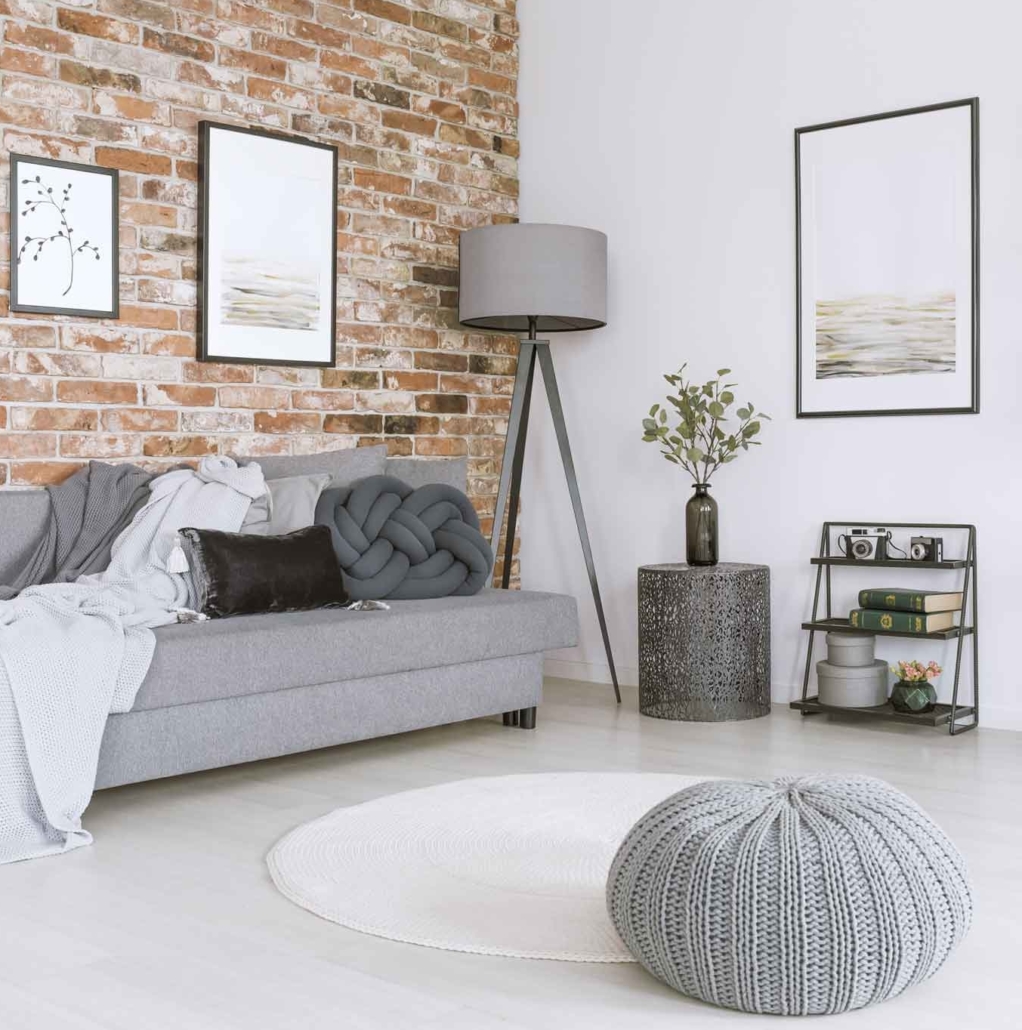 Weißes und graues Wohnzimmer mit Backsteinwand